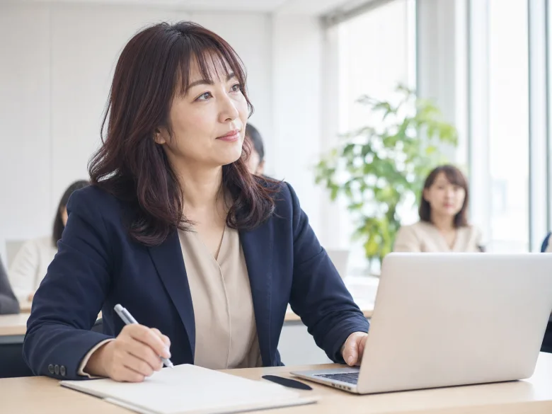 明るいセミナールームでノートPCに向かう40代の日本人女性参加者のイメージ