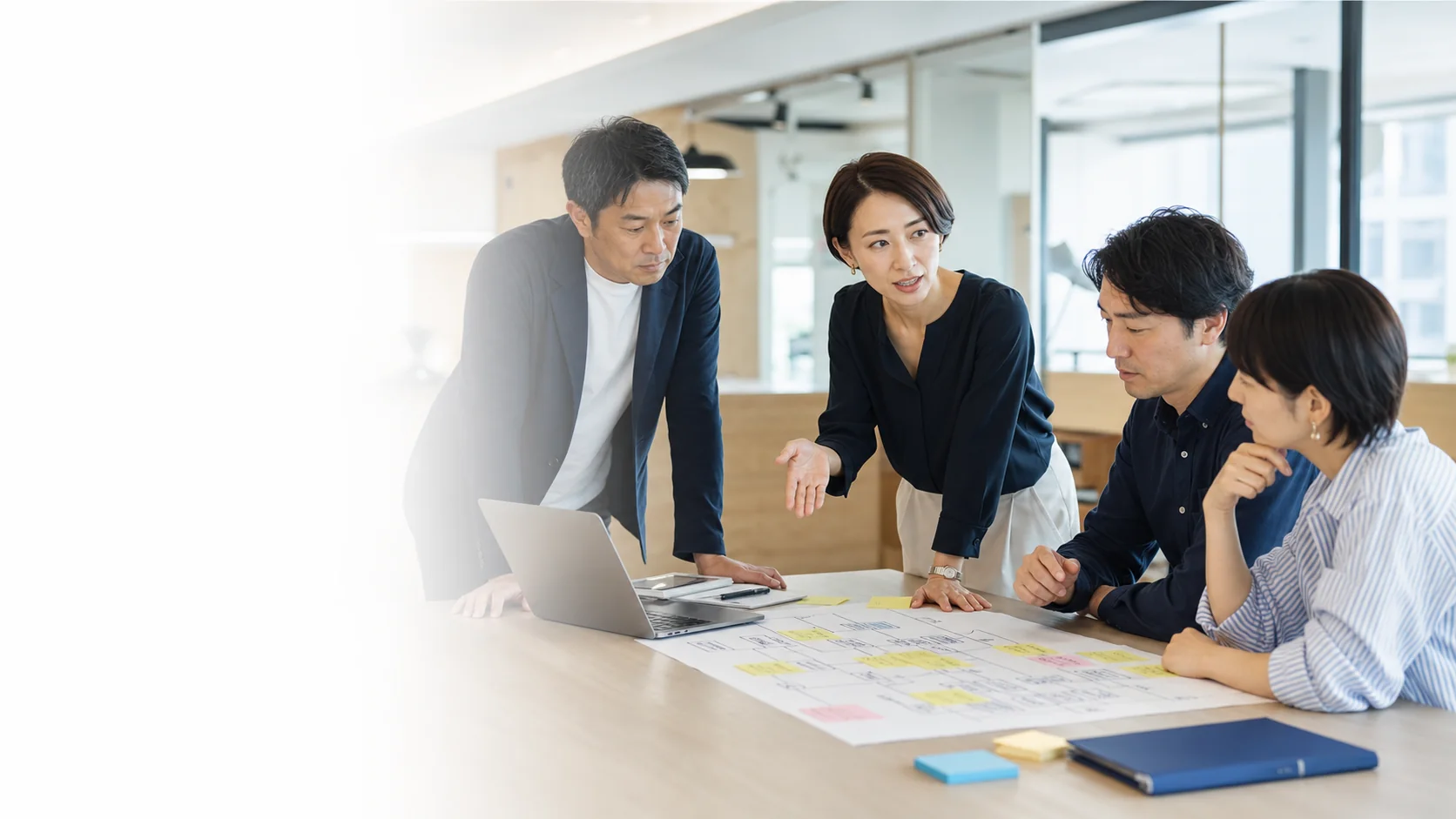 企業の現場で業務を整理し、AI実装について話し合うチーム